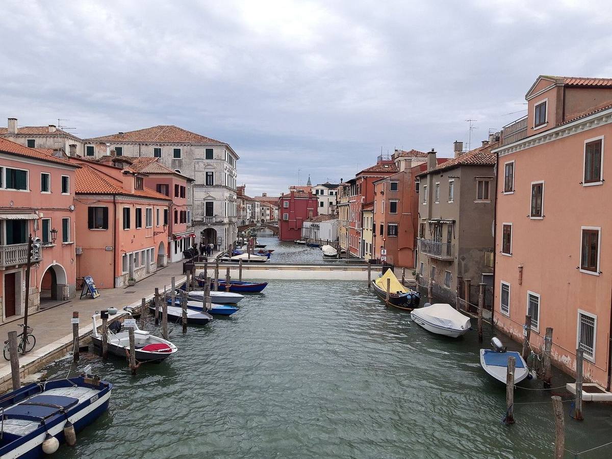 Canale con barche e facciate rosa